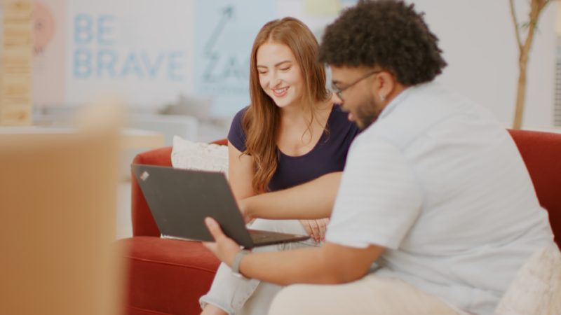 employees collaborate on laptop