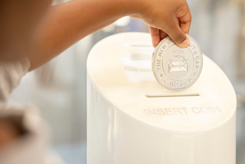 giant coin going into carvana vending machine