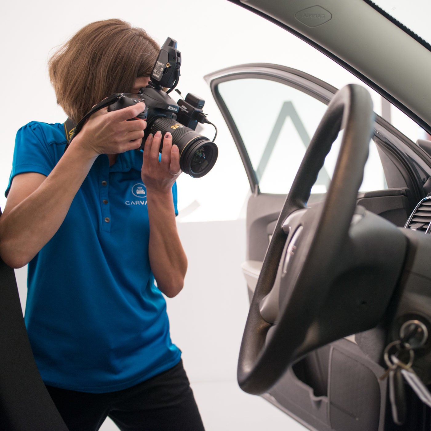female employee photographing vehicle interior